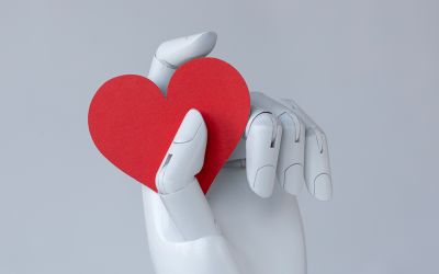 Graphic of a robot hand holding a red heart to illustrate the article 