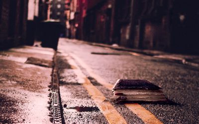Photo of a Bible on a city street at night, to illustrate the article Truth Is Fallen in the Street
