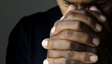 A man's clasped hands to illustrate Praying for Protection